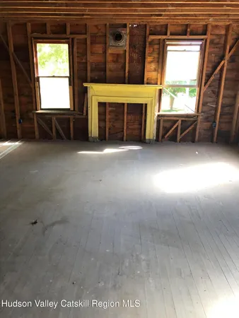 wooden floor in an empty room with a fireplace