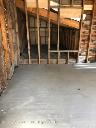 a view of an empty room with wooden floor and windows