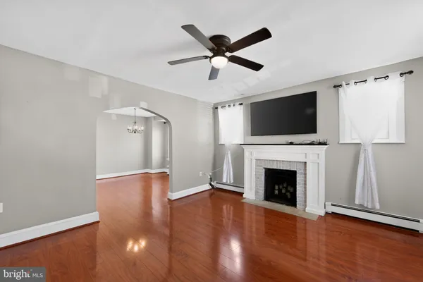 a living room with wooden floor and a fireplace