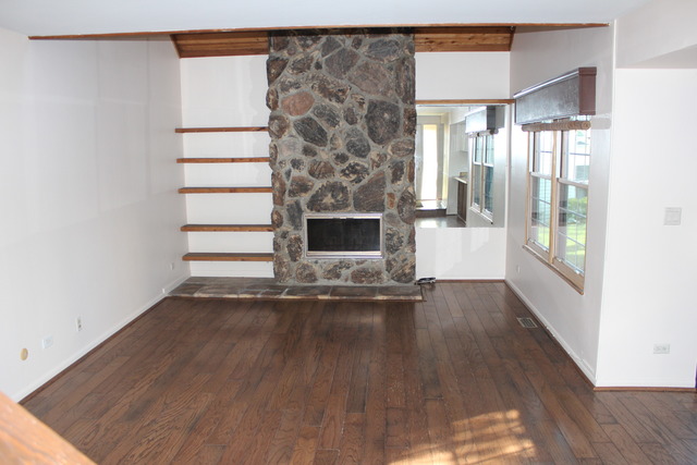 704 Wakefield Road Gurnee, IL 60031 - Photo 3 of 20 a view of empty room with wooden floor and fireplace