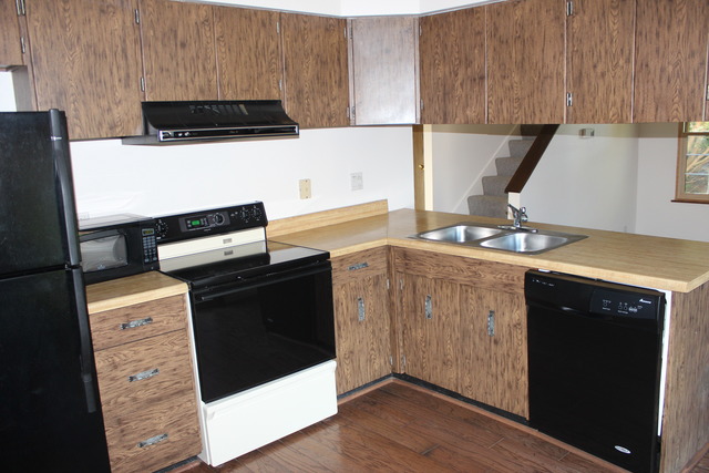 704 Wakefield Road Gurnee, IL 60031 - Photo 6 of 20 a kitchen with stainless steel appliances a stove a microwave and white cabinets