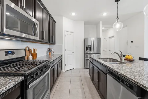 a kitchen with granite countertop stainless steel appliances and wooden cabinets