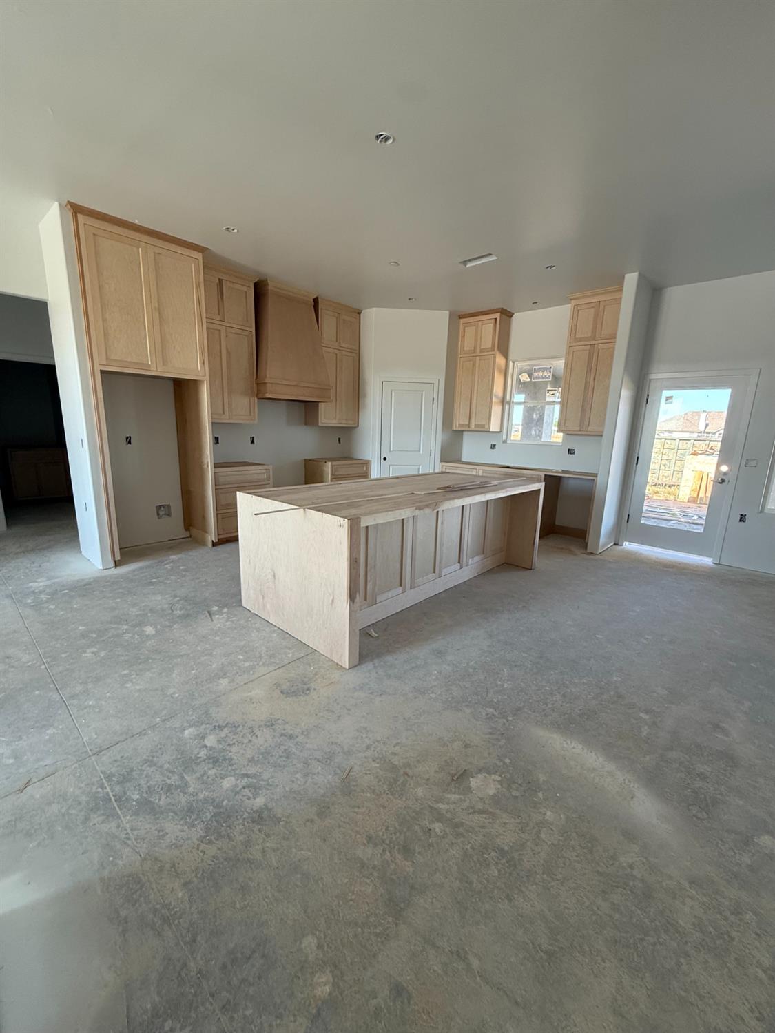 21250 Del Monte Road Madera, CA 93638 - Photo 10 of 17 a large white kitchen with cabinets a sink a window and a couch