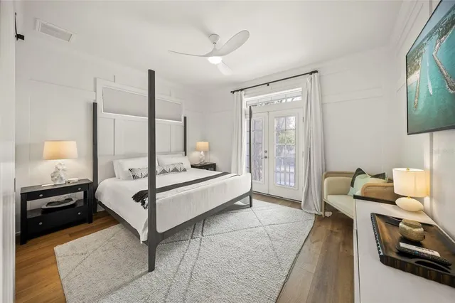 a bedroom with a bed and a flat tv screen on wall