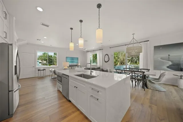 a kitchen with a sink a counter top space appliances and a center island