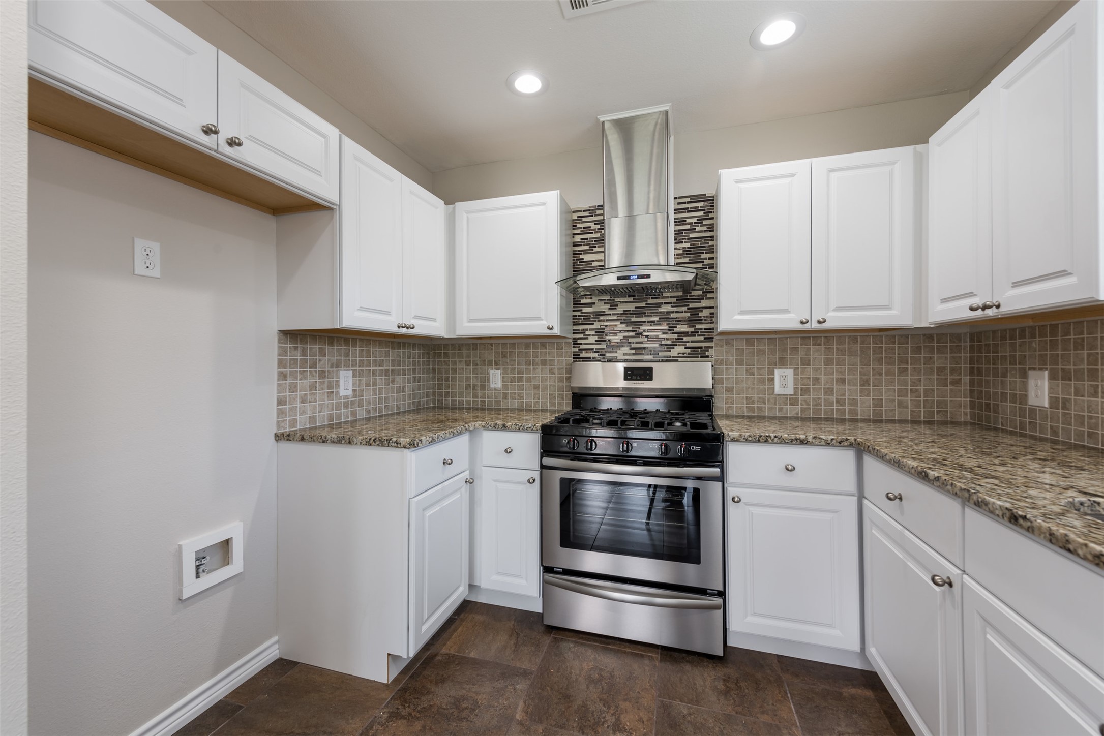 5703 Teri Road Austin, TX 78744 - Photo 7 of 16 a kitchen with stainless steel appliances granite countertop a stove and white cabinets