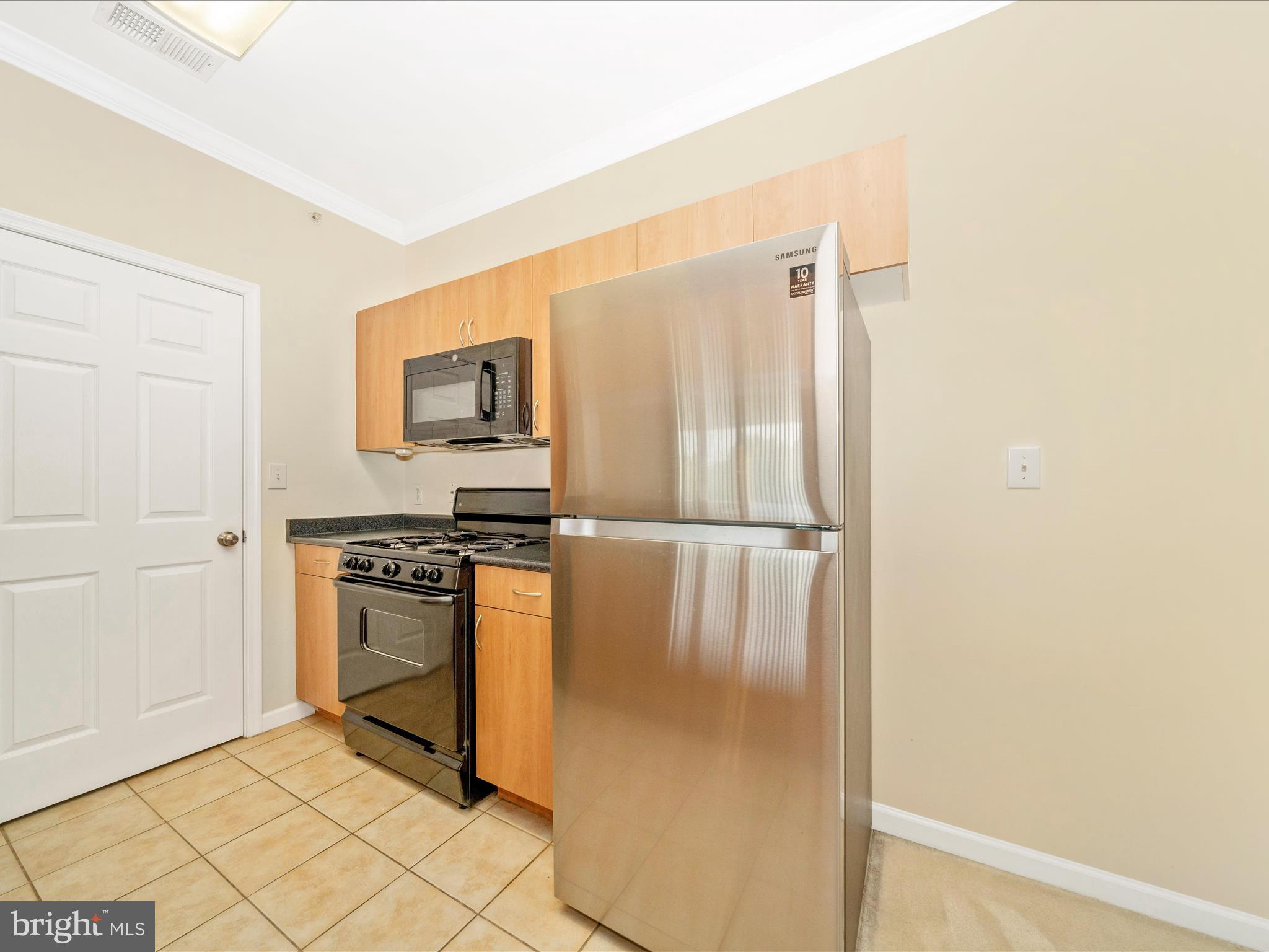 19606 Galway Bay Circle, Unit 401 Germantown, MD 20874 - Photo 15 of 50 a kitchen with granite countertop a refrigerator and a stove