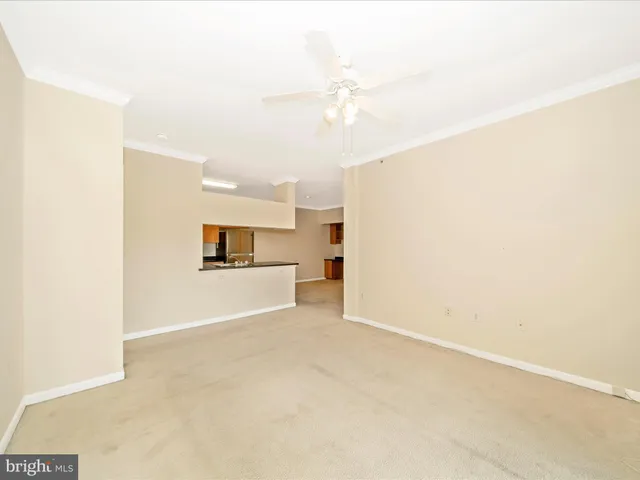 a view of an empty room with a chandelier fan