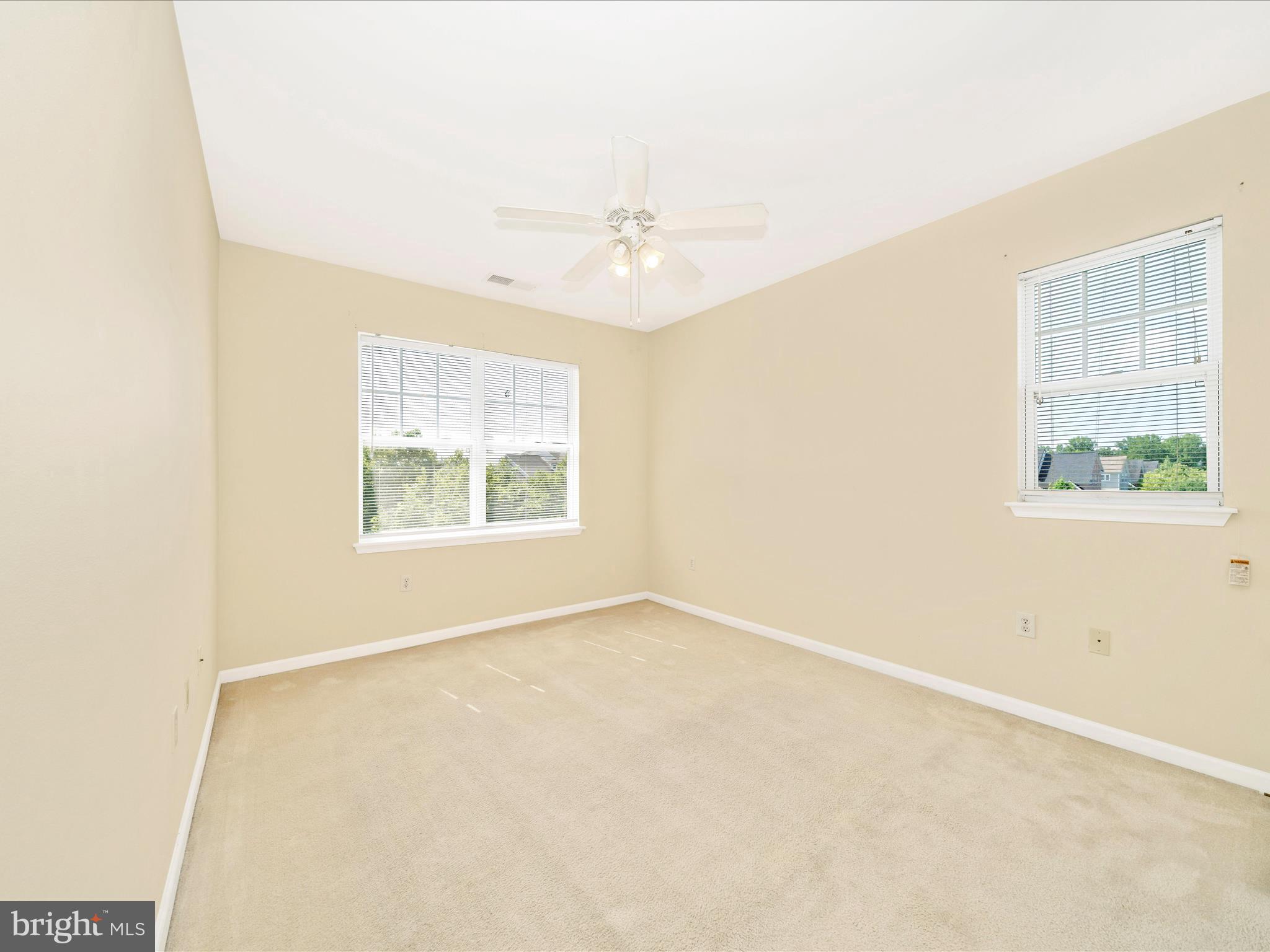19606 Galway Bay Circle, Unit 401 Germantown, MD 20874 - Photo 23 of 50 an empty room with windows and ceiling fan