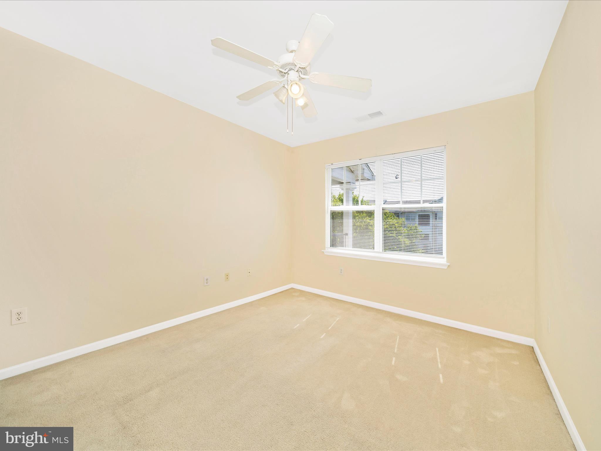 19606 Galway Bay Circle, Unit 401 Germantown, MD 20874 - Photo 26 of 50 an empty room with windows and ceiling fan