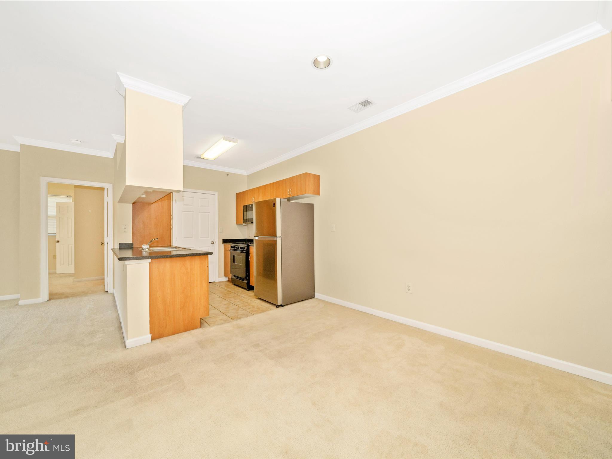 19606 Galway Bay Circle, Unit 401 Germantown, MD 20874 - Photo 9 of 50 a view of kitchen and empty room with wooden floor