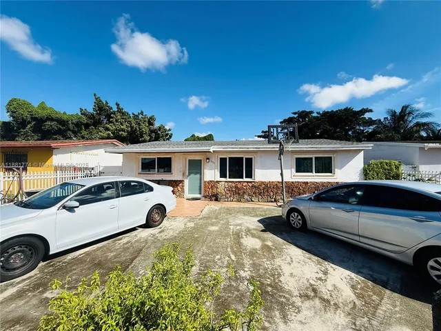 a view of a white car parked in front of a house