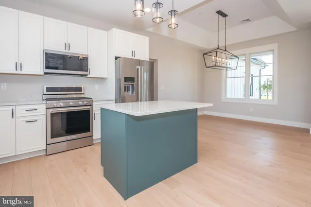 a kitchen with stainless steel appliances a refrigerator sink and microwave