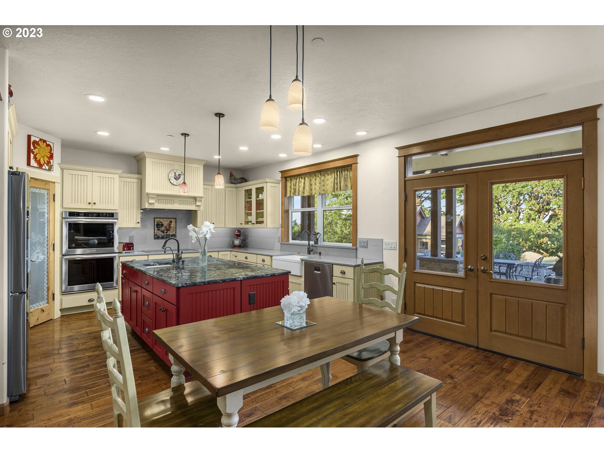 4185 Southwest Lafollett Road Cornelius, OR 97113 - Photo 7 of 45 a kitchen with stainless steel appliances kitchen island granite countertop a refrigerator a stove top oven and a dining table with wooden floor