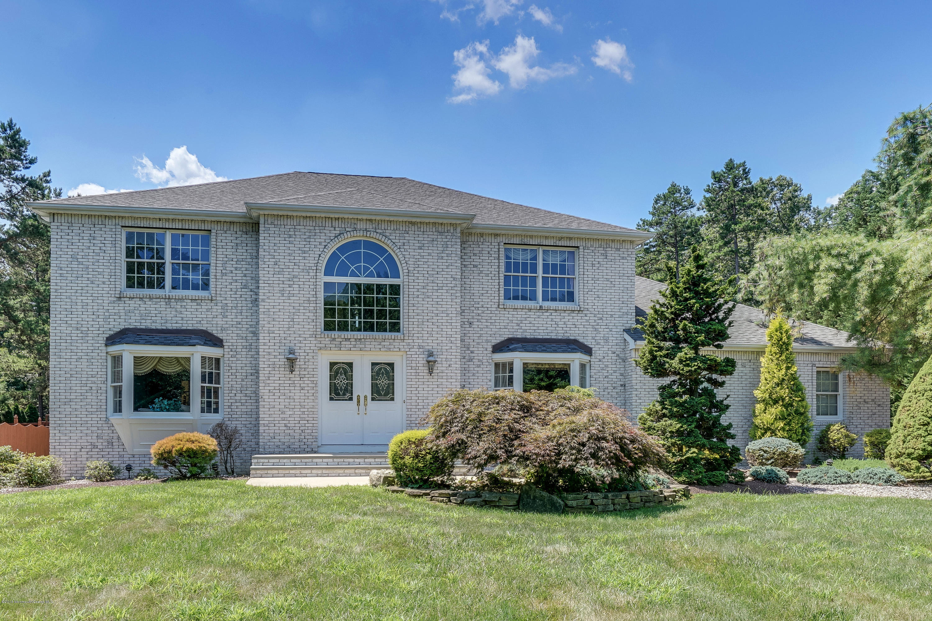a front view of a house with a garden and yard