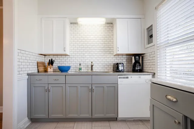 a kitchen with cabinets appliances a sink and a window