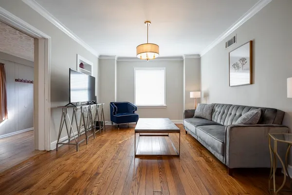 a living room with furniture and wooden floor