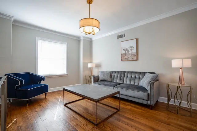a living room with furniture and a wooden floor