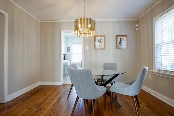 a view of a dining room with furniture a chandelier and wooden floor
