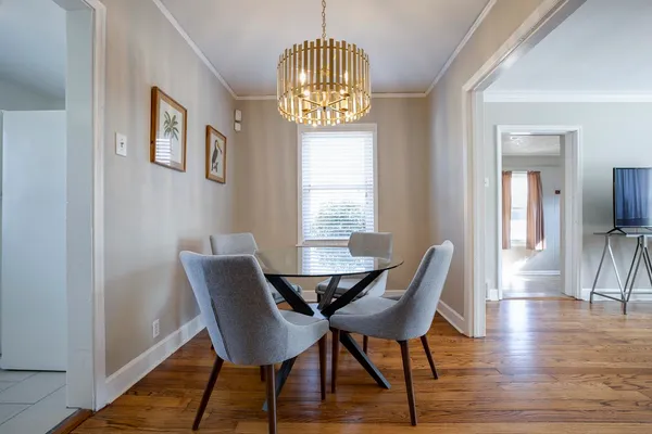 a view of a dining room with furniture wooden floor and a chandelier