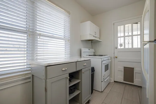 a kitchen with cabinets appliances and a window