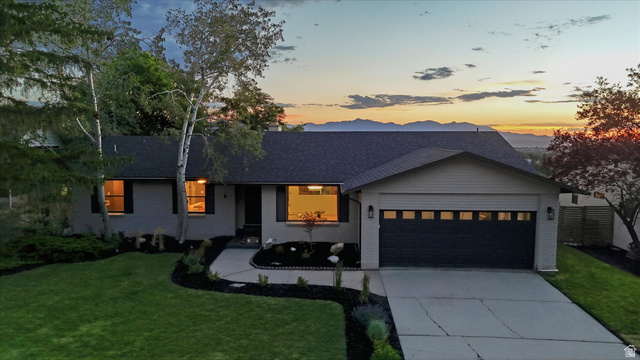8760 Rustler Road Cottonwood Heights, UT 84093 - Photo 57 of 57 Single-story residence featuring a two-car garage with transom windows, a concrete driveway, and a dark asphalt shingle roof
