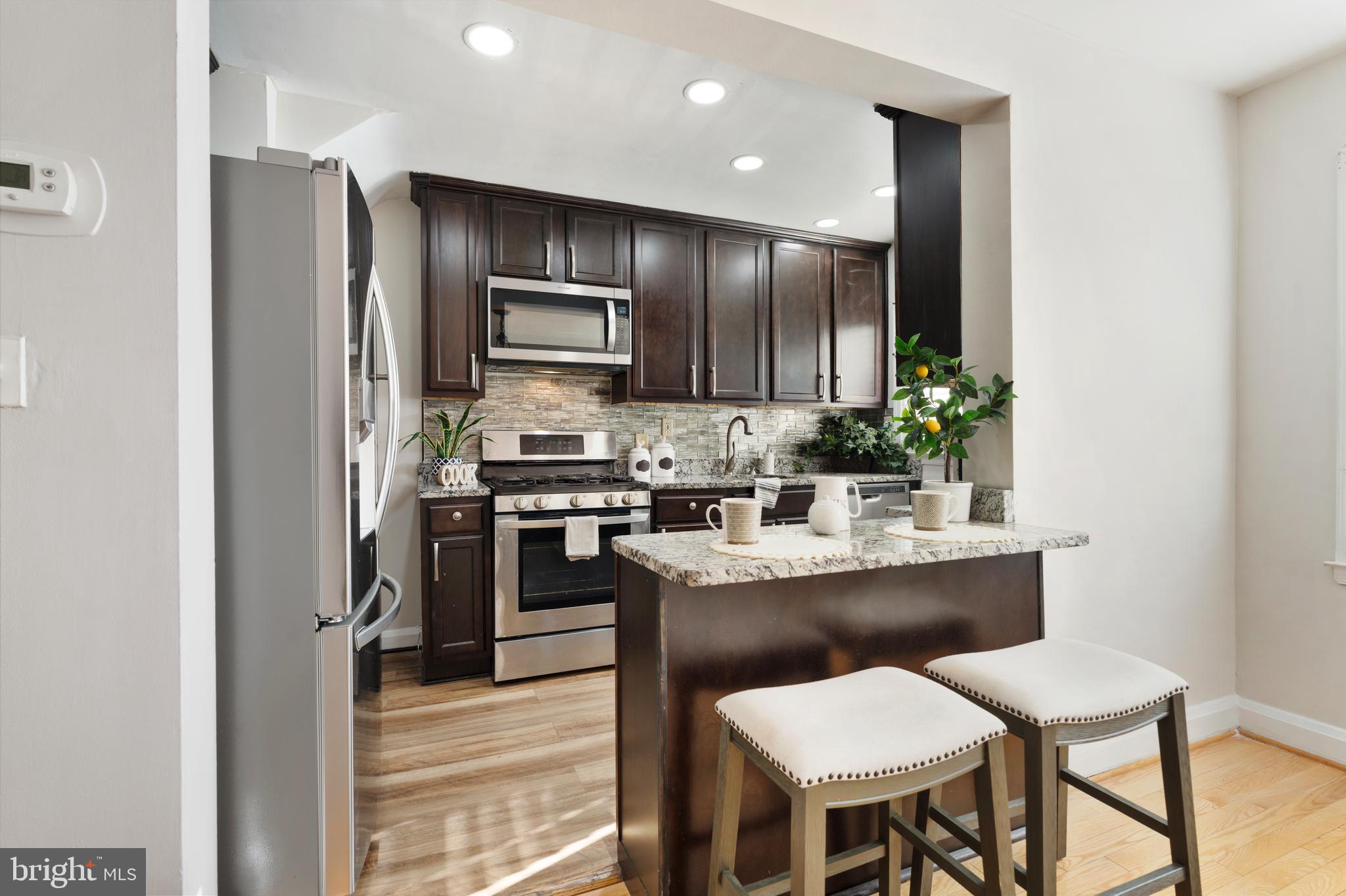 404 Grovethorn Road Baltimore, MD 21220 - Photo 12 of 39 a kitchen with kitchen island cabinets and stainless steel appliances