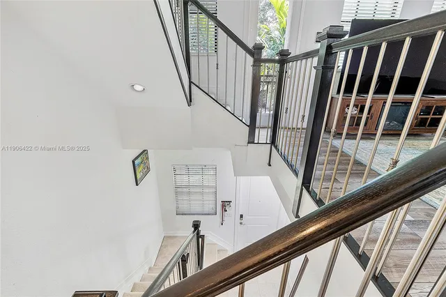 a view of staircase with railing and white walls
