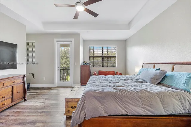 a bedroom with a large bed and a flat tv screen on dresser