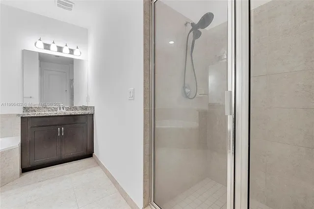 a bathroom with a shower a sink and a mirror