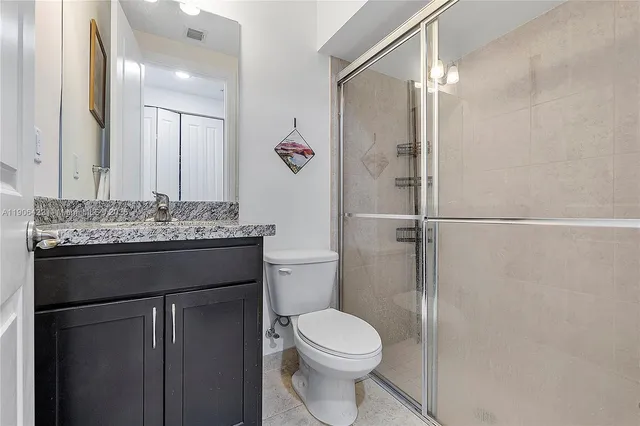 a bathroom with a granite countertop sink toilet and shower