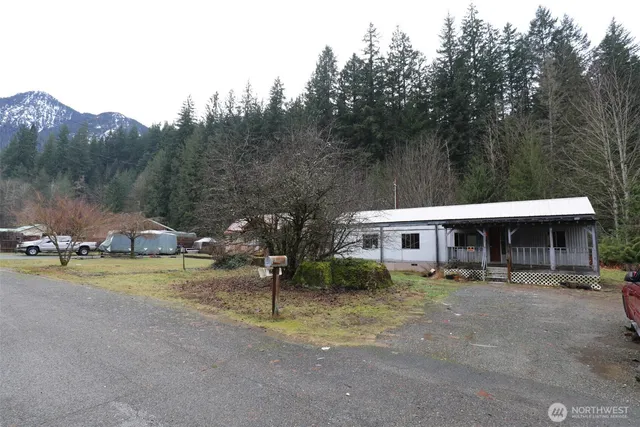 a front view of a house with garden and trees
