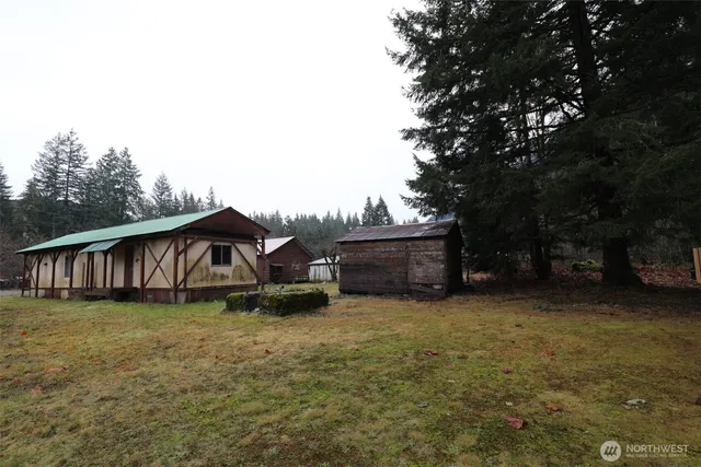 a view of a house with backyard and trees