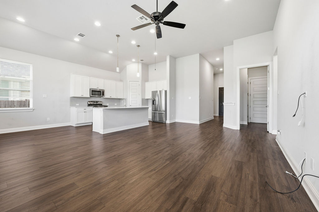 2032 Base Burner Path Leander, TX 78641 - Photo 9 of 34 Spacious living area featuring wood-finish flooring, vaulted ceilings, and recessed lighting