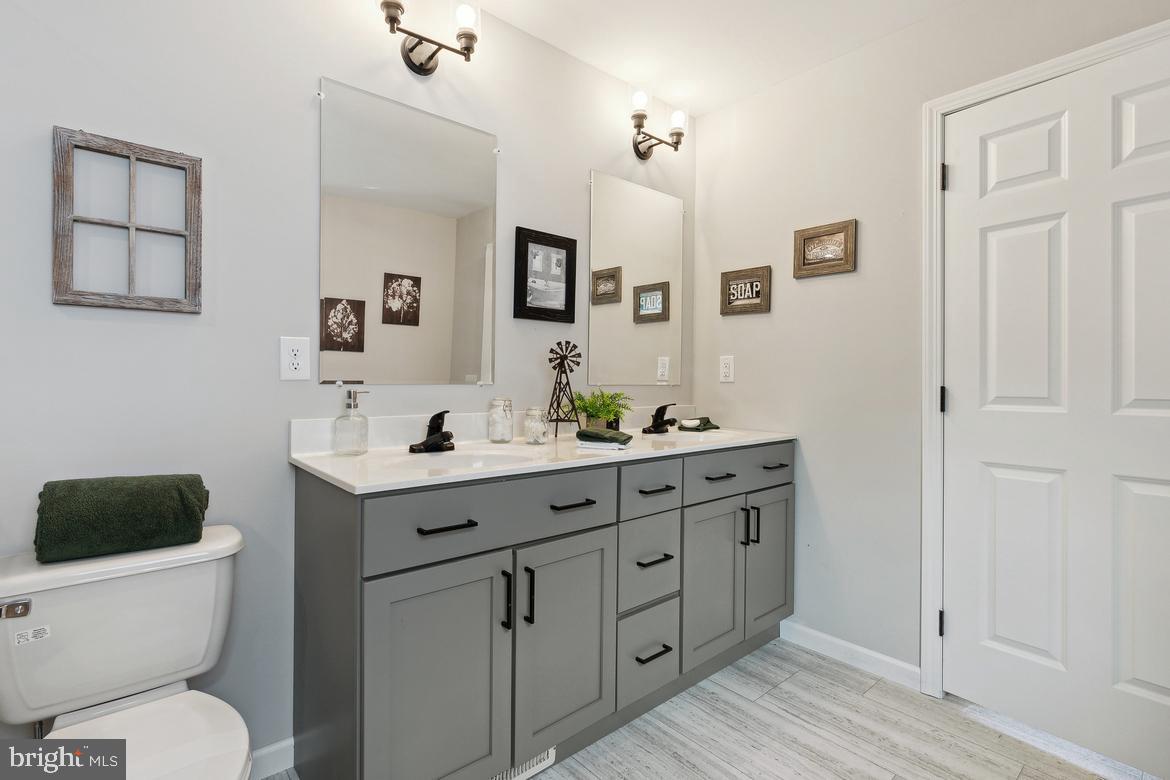 474 Riverside Avenue Trenton, NJ 08618 - Photo 6 of 9 a bathroom with a toilet a sink a mirror and vanity