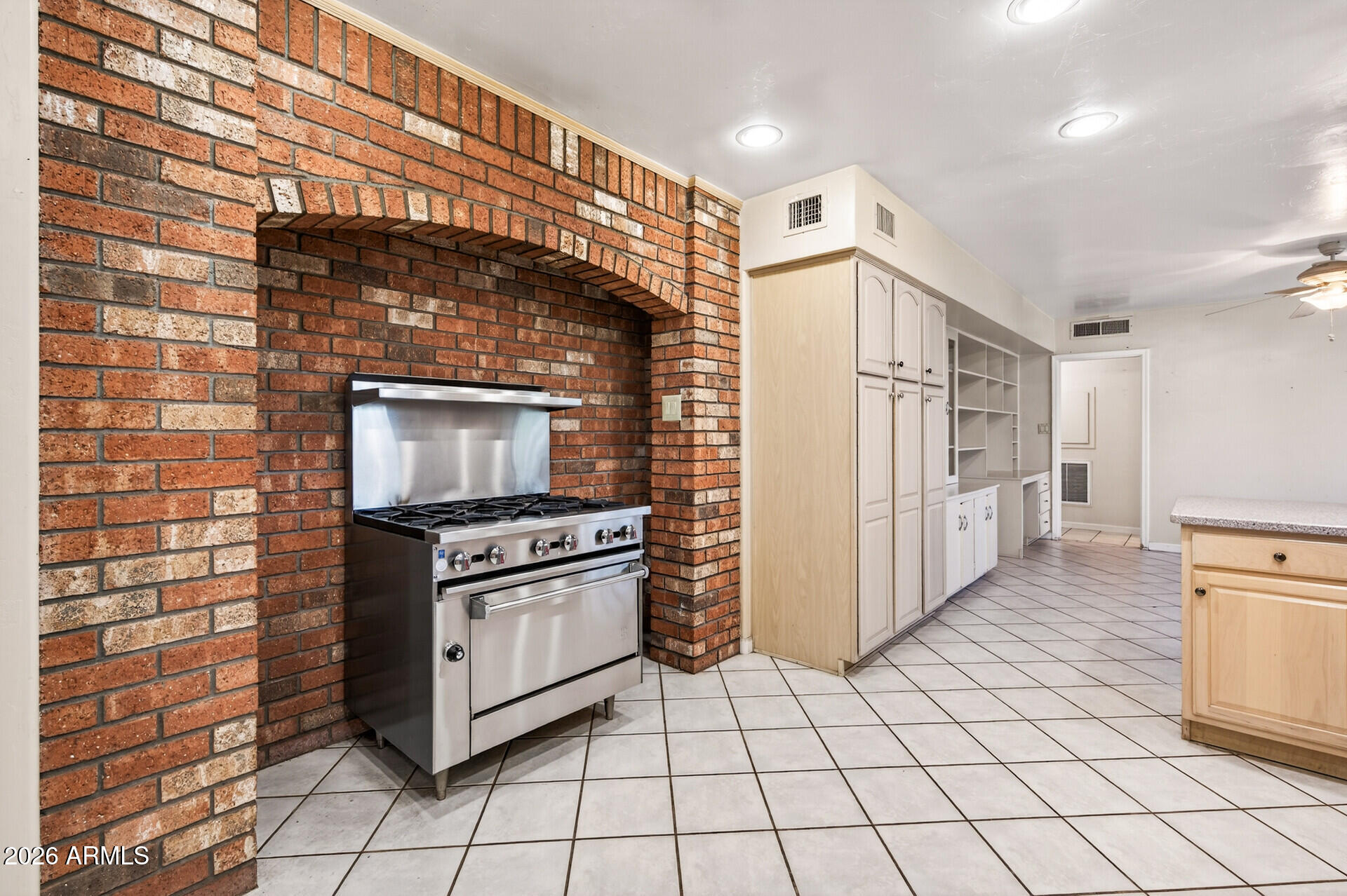 7730 North 7th Avenue Phoenix, AZ 85021 - Photo 5 of 14 a kitchen with granite countertop a stove a refrigerator and a cabinets
