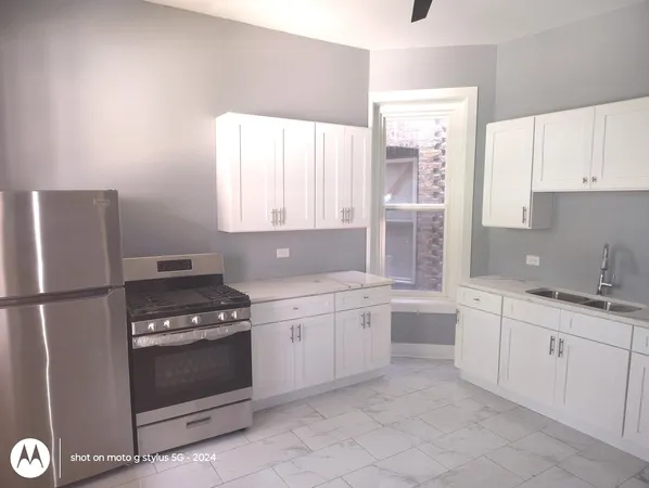 a kitchen with white cabinets and white appliances