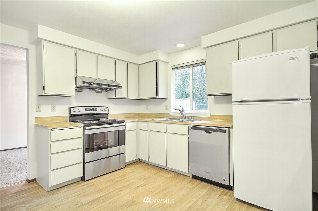 2209 Southeast 21st Street Renton, WA 98055 - Photo 13 of 40 a kitchen with white cabinets and white appliances