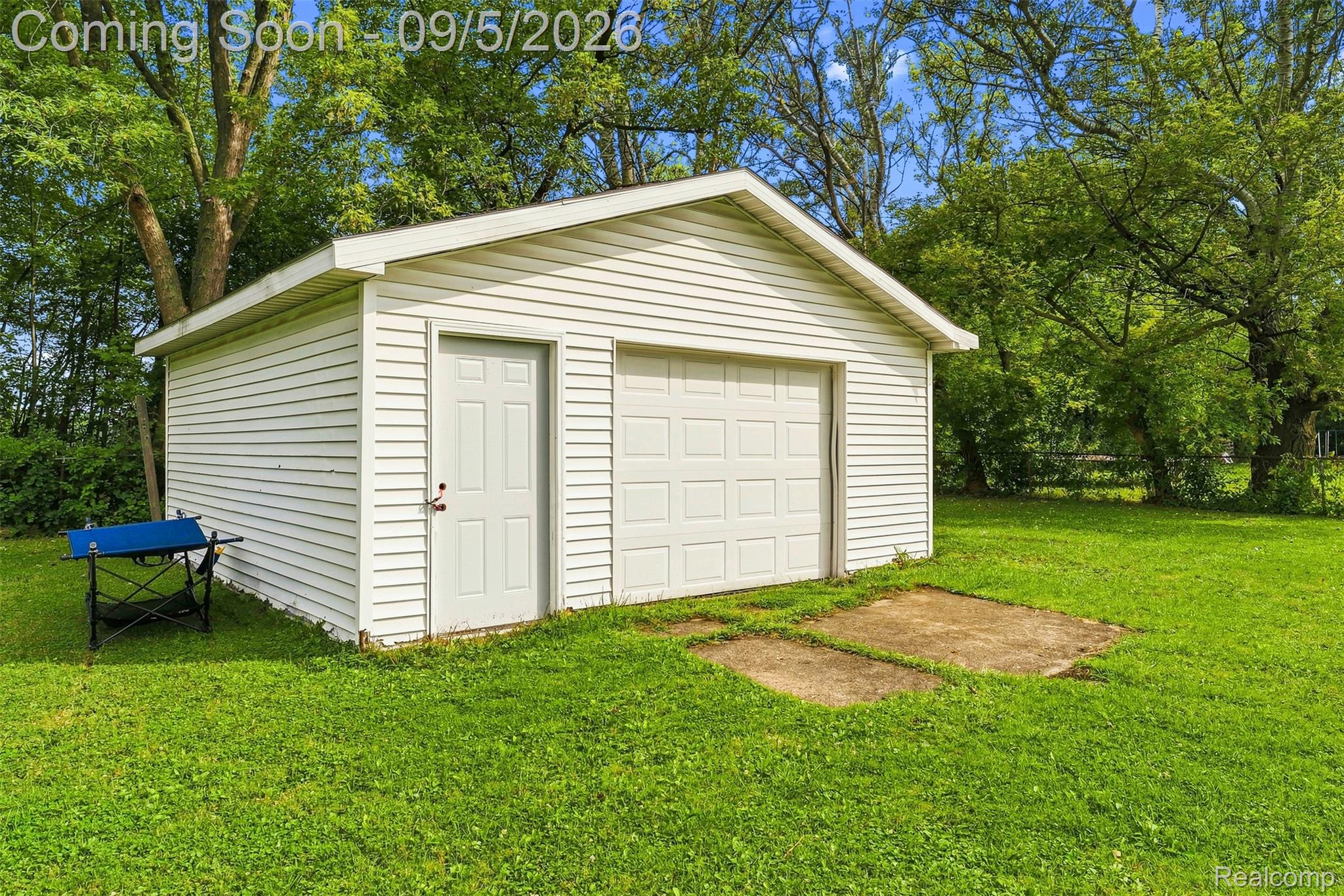 2071 East Dodge Road Clio, MI 48420 - Photo 35 of 38 Detached garage with horizontal siding, a single overhead door, and a dedicated entry door