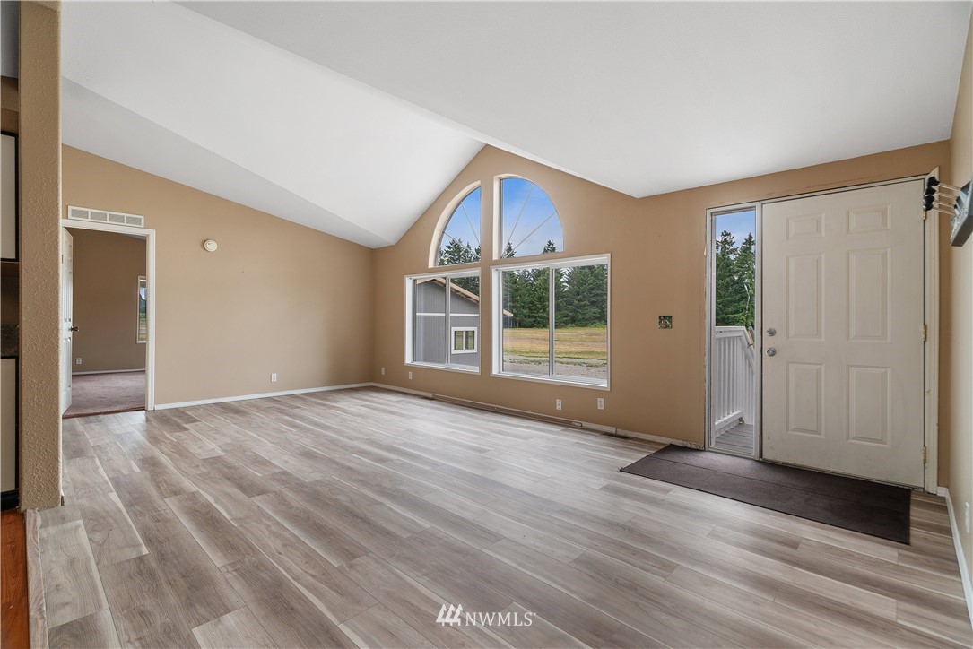 3925 183rd Avenue Southwest Rochester, WA 98579 - Photo 2 of 33 an empty room with wooden floor and windows