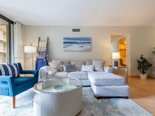 a kitchen with stainless steel appliances granite countertop a refrigerator a stove top oven and white cabinets with wooden floors