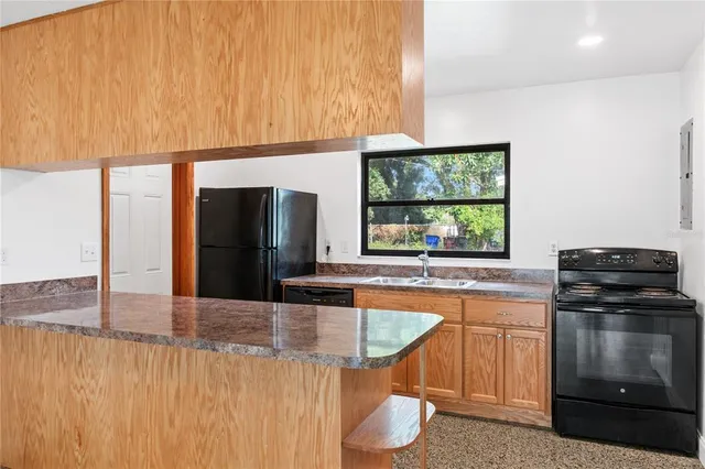 a kitchen with stainless steel appliances granite countertop a sink and a stove with granite countertops