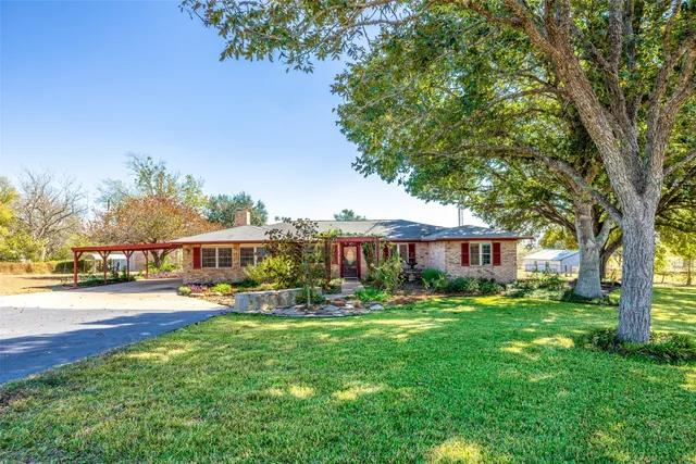 a front view of a house with a yard and trees