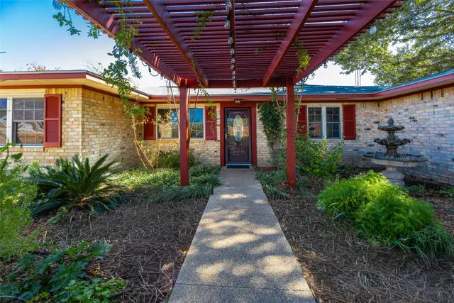 a view of a porch with a wooden floor next to a yard