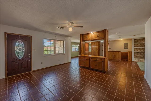 a hallway with wooden floor fireplace and windows