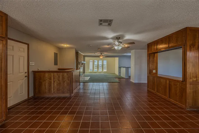 a view of a hallway with wooden floor and a kitchen