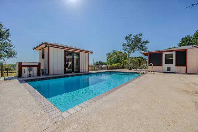 a view of a house with a yard and a large tree