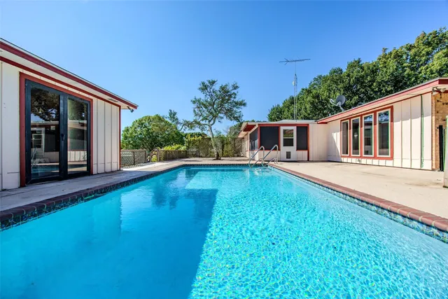 a view of a house with pool and chairs