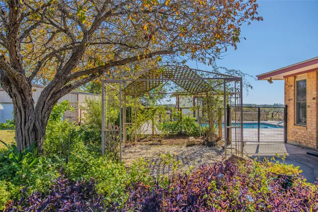 a view of a pathway with a flower garden