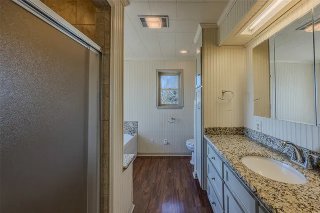 a bathroom with a granite countertop double vanity sink and a mirror